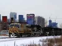 A 114-car CN 305 has power in CREX and NS paint schemes (CN 3938 & NS 4110) as it passes the skyline of downtown Montreal.