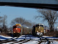 Both CN 271 (at left with class leader CN 5600 leading) and CN 305 (at right with CN 3946 leading) have clear signals ahead as they head west through Dorval side by side.