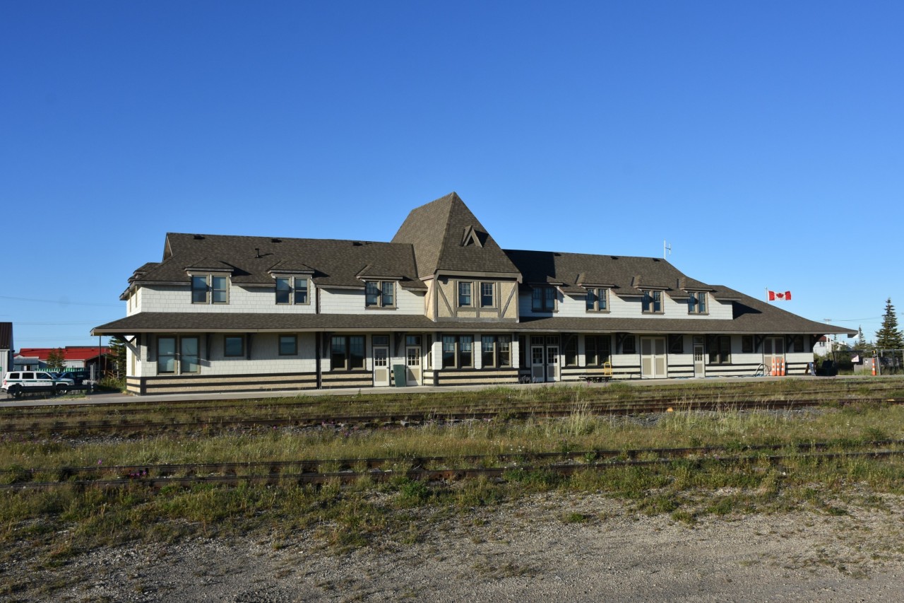 For those who like full frontal views, here's a platform side shot of the former CN station, now VIA/Parks Canada building in beautiful downtown Churchill, MB. A pleasant mid-summer breeze has the Canadian flag stretched out nicely for the photo, and the old baggage dolly on the platform is a reminder of how luggage was once moved about prior to pickup trucks becoming the new normal. It won't be long before some repairs and a fresh coat of paint will be required on this stately old building, but it looks absolutely wonderful in the bright sunshine and super blue sky background on this early evening of August 2, 2022.