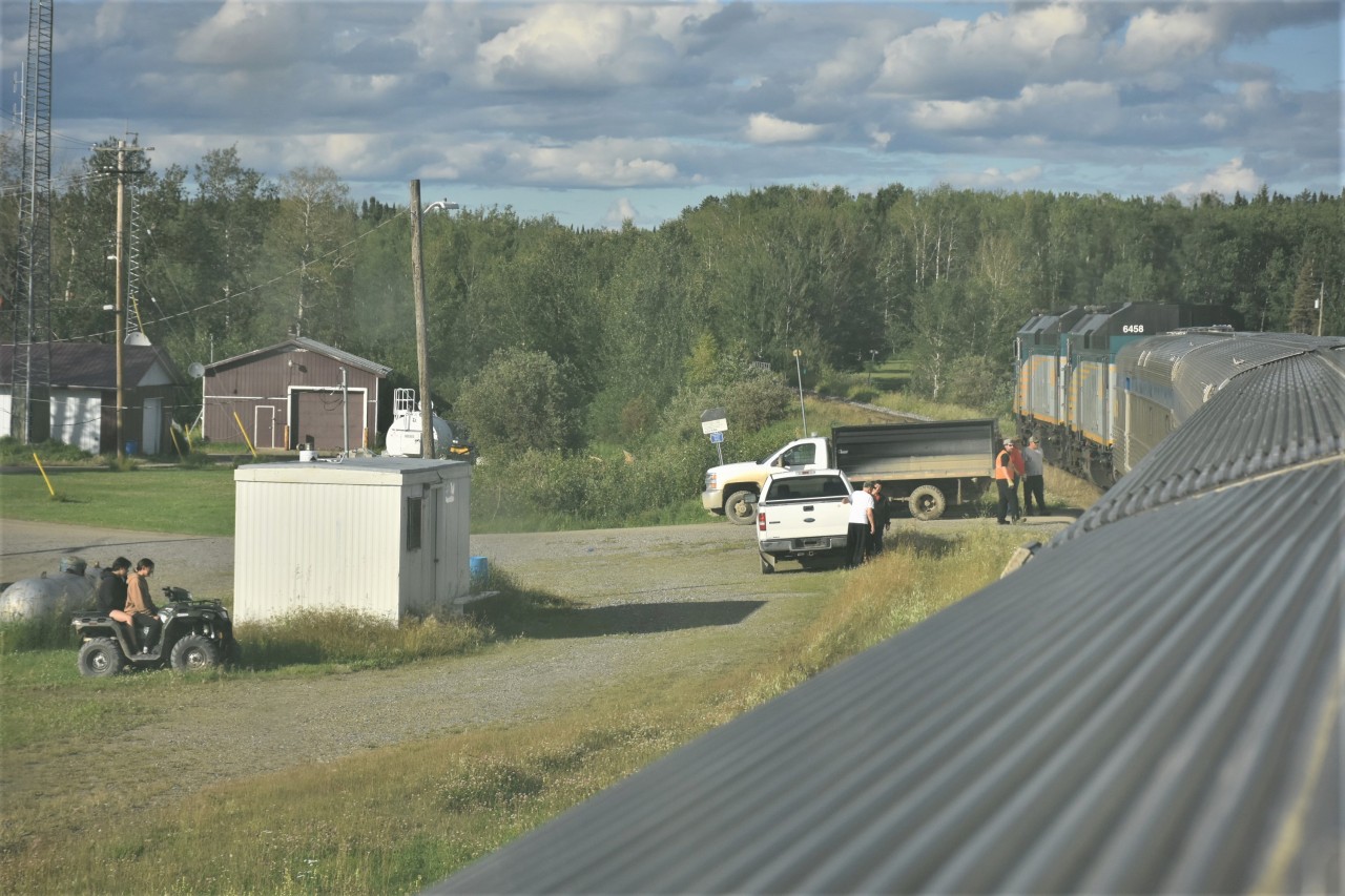 Next station stop will be Pikwitonei, MB Mile 213.3 HBR Thicket Sub. Another shot I had to take from inside the train as the vestibule doors were not opened for passengers to detrain on the northbound journey to Churchill. I'm in VIA 8515 Skyline and trying to pick the cleanest area of the bug splattered window to get a decent shot. VIA 693 will come to a stop when the baggage car door lines up with the road crossing. The Pikwitonei station is located near Railway Avenue & Sandy Bay Road in this remote village. Located approximately 47 km (29.2 mi) from Thompson, MB, the community is served by Via Rail at the Pikwitonei railway station. It was nice to see some of the town folk come down to greet the train.