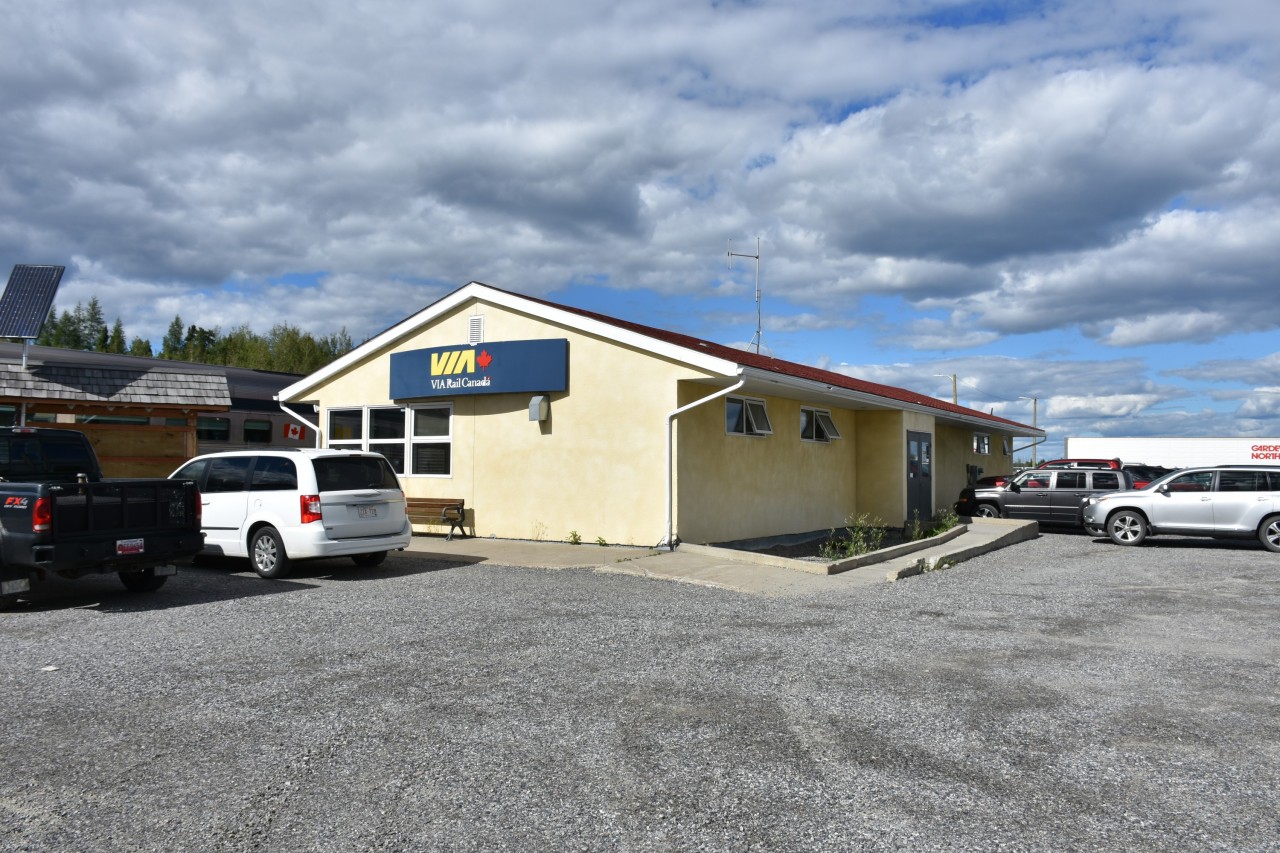 Street side view of VIA Rail's Thompson, MB station located at Mile 30.5 Thompson Sub. has VIA 693 standing at the platform with doors open to allow passengers a chance to get off and limber up a bit before continuing the journey to Churchill.