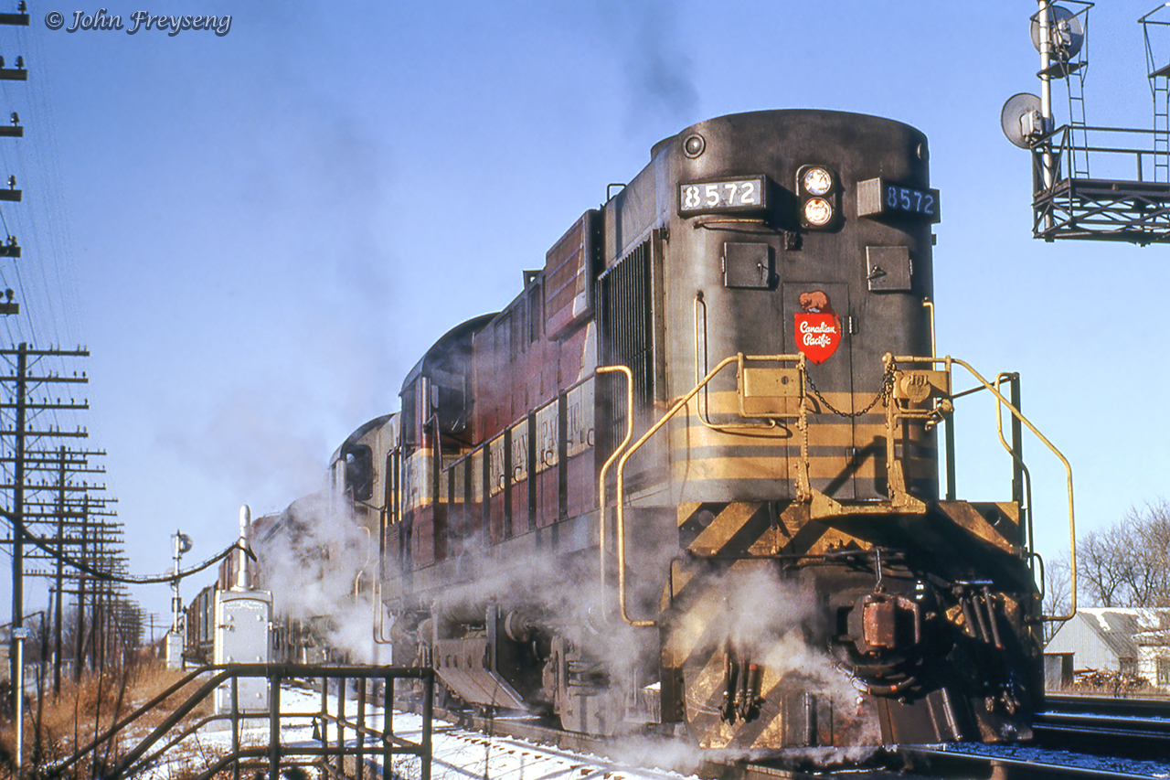 Eastbound CPR Agincourt to Montreal freight 906 rolls across the Cornelia Street/Highway 15 overpass in Smith Falls behind a pair of MLW road switchers and leased Chicago Great Western F7A 156. This scene was captured during a trip to Smith Falls to ride train 21, a former CNR/CPR pool train, before cancellation as the pool agreement had been cancelled a few months previous.With both the Canadian National and Canadian Pacific Railways seeing sharp declines in ridership during the Great Depression, both companies entered into an agreement to pool some competitive passenger services on Toronto - Montreal and Toronto - Ottawa routes where both operators had similar schedules. The agreement would come into effect April 2, 1933. Montreal - Quebec City operations were added the following year. This agreement would come to an end at midnight on October 30, 1965. CPR overnight pool trains 33 & 34 became CPR daytime RDC runs Toronto - Peterborough - Havelock - Smiths Falls - Bedell Jct. - Ottawa. The CPR overnight pool trains 21 & 22 became luxury late afternoon trains Toronto - Belleville - Smiths Falls - Montreal using equipment from CPR's Canadian, including dining car and dome-observation lounge Park cars in a vain attempt to compete with CN’s afternoon Rapido’s to/from Montreal. By January 1966, it had become obvious that CP couldn’t effectively compete with the Rapido’s, so CP applied and was granted permission to terminate trains 21 & 22. Wanting to ride #21 before it was discontinued, on this Saturday I made a trip on RDC equipped Ottawa train 33 to Smiths Falls and returned to Toronto on train 21, now named the Royal York. The eastbound counterpart, train #22, carried the name Le Chateau Champlain.  Both trains being named after CP hotels at each of their destinations.Scan and editing by Jacob Patterson.