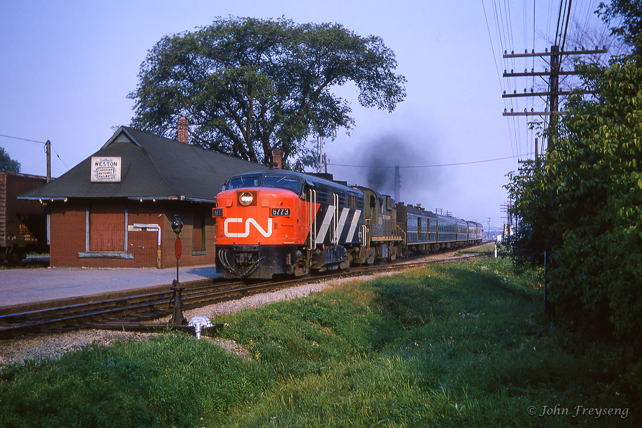 Toronto - London express passenger 37 throttles up passing CN's Weston station at roughly 1715h.  This was the third station at Weston, built in 1905 just south of John Street, it would serve passengers until its demise in 1966.  Within the year, this portion of the Brampton Subdivision will become the Weston Subdivision with the opening of the Toronto bypass and CN's Toronto Yard, now MacMillan Yard.Scan and editing by Jacob Patterson.