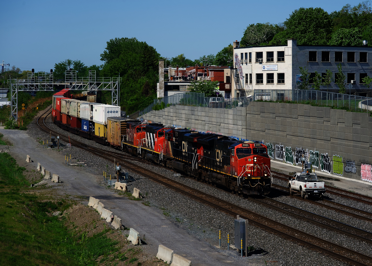 CN 120 has two geeps and an inspection boxcar trailing behind the road power as it passes a foreman. Unit numbers are CN 3080, CN 3845, CN 9410, CN 4789 & CNIS 412040.