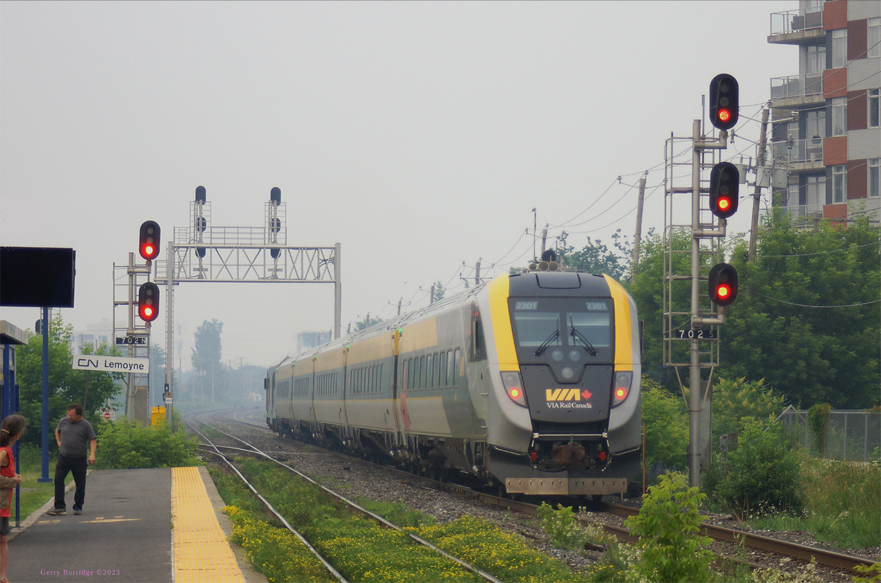 VIA Rail Canada train 28(Ottawa-Montreal-Quebec) consisting of one of the Siemens Venture trainsets now in service(here, cab-coach 2301 on rear and SCV-42 2202 at far end) resumes eastward journey following St Lambert station stop in the heavy smoke conditions in Montreal region, rated the worst in the world Sunday, caused by forest fires in the Abitibi Region of north-west Quebec.