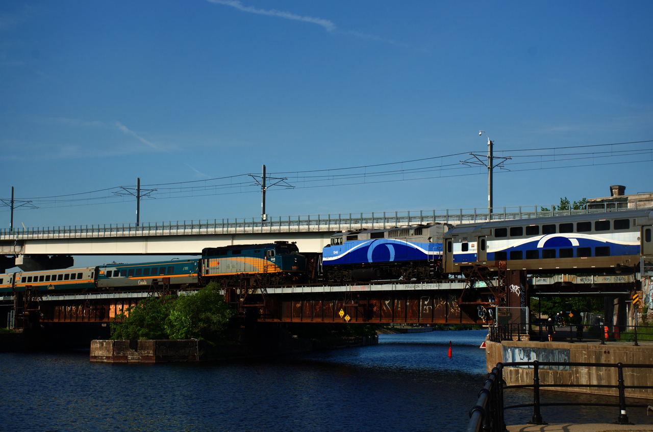 VIA 6448 & EXO 1346 are about to pass each other as they cross the Lachine Canal. VIA 6448 is leading VIA 22 towards Central Station and EXO 1346 is leading a deadhead move going in the opposite direction.