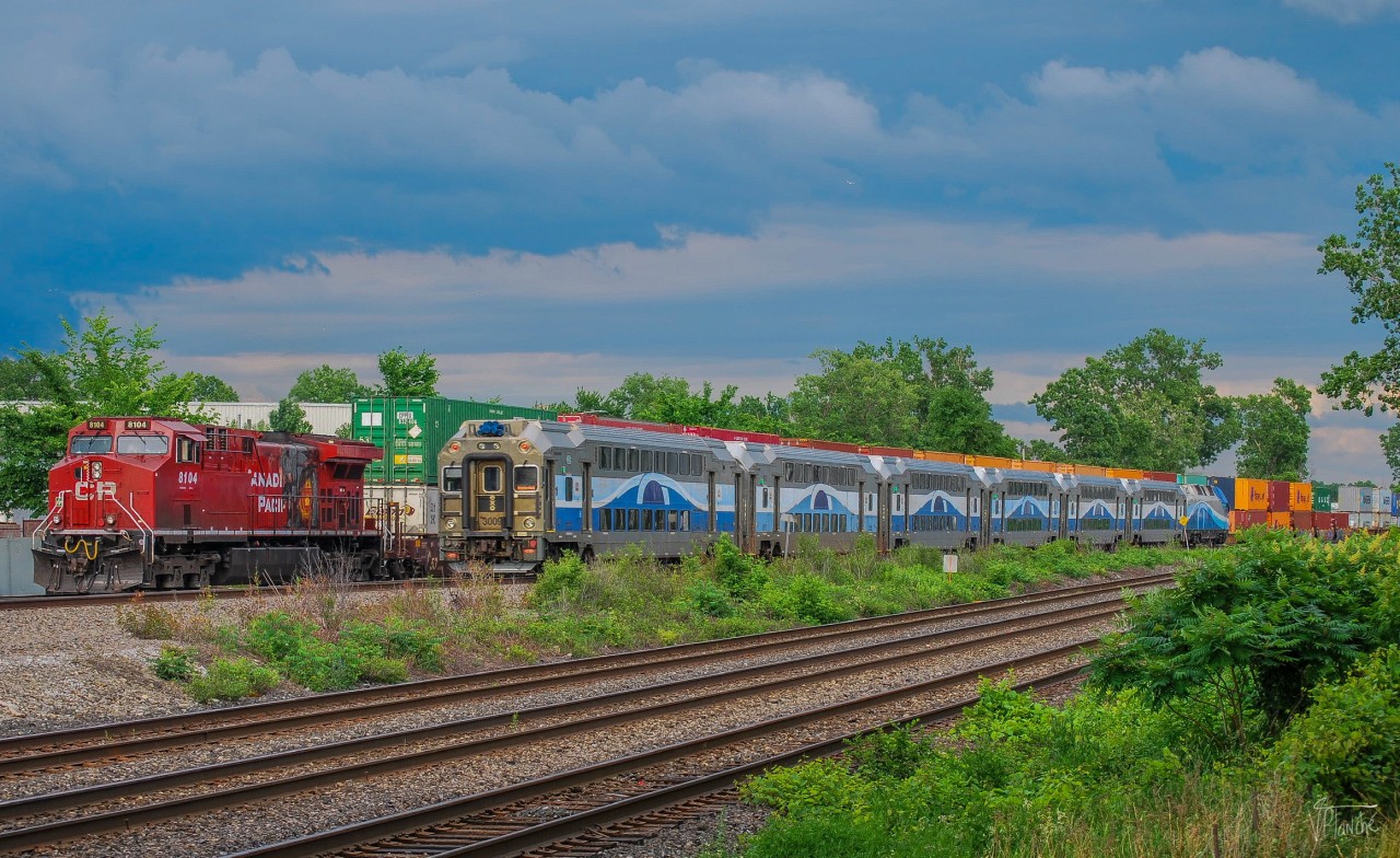 On June 26, 2023, CPKC 119 awaits its signal on the ramps of Dorval. The EXO 26 to destination 26 crosses it and it will then be the CPKC to pass.