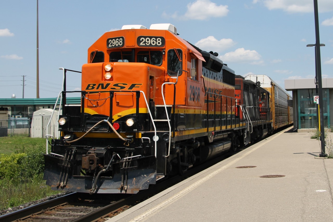 BNSF 2698 leads veteran GP9 CN 4125 on Track 1 through Bronte GO station with L554's train trailing.