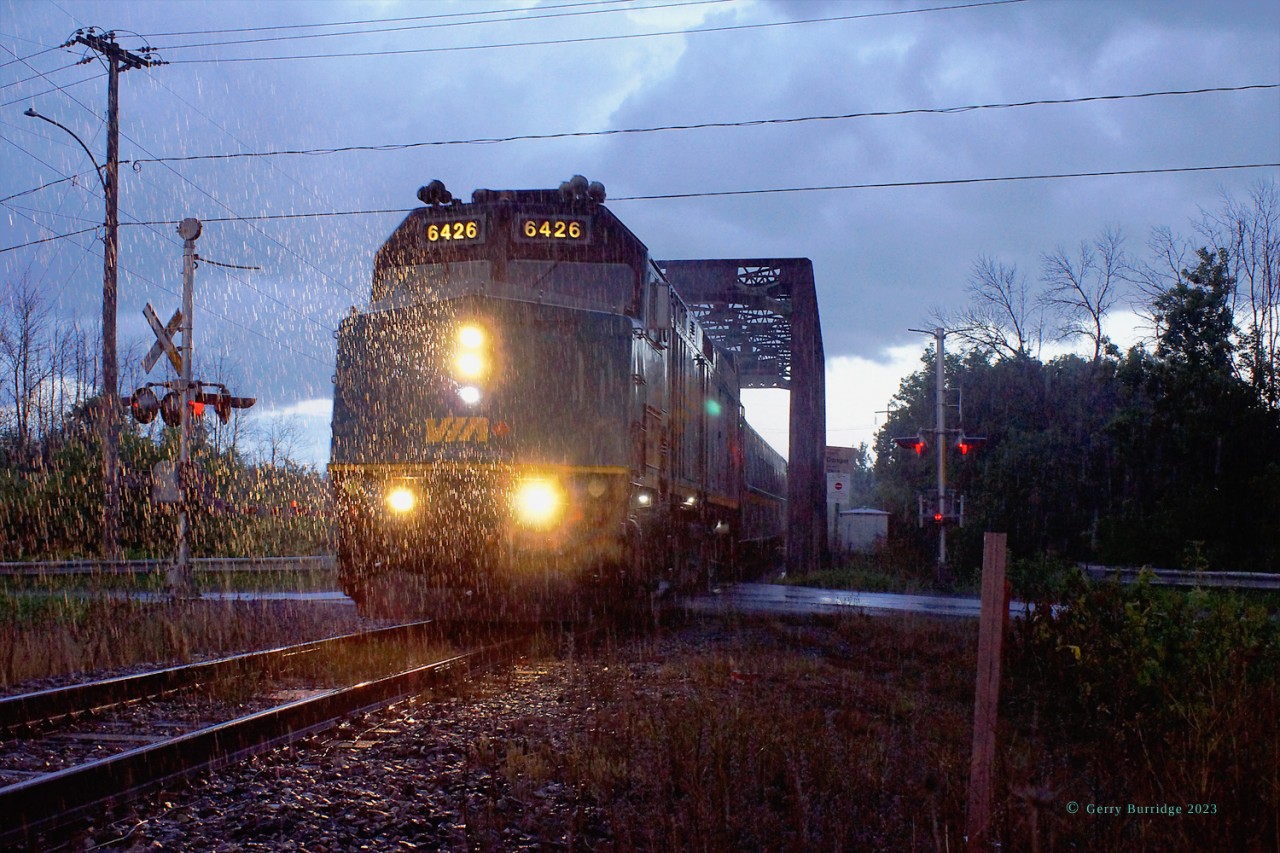 As it comes off the bridge over the Delisle River to start up the Alexandria Sub to Ottawa VIA F40PH-3 6426 and its trailing LRC coaches(and any and all in the vicinity...) are caught in the drenching rain and half-light of an unfortunately timed summer shower.