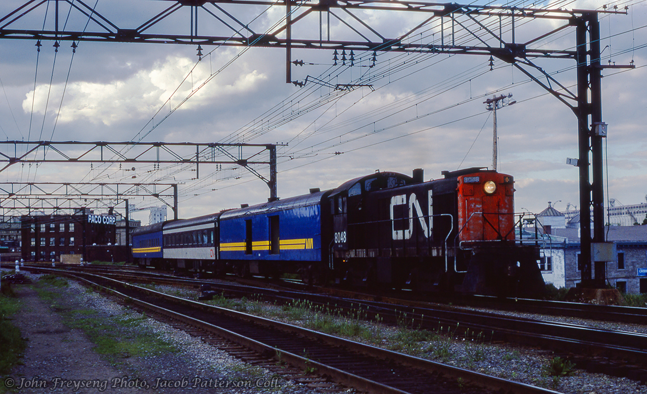 One mile out of Montreal Gare Centrale, CN 8048 leads an equipment move to Pte-St-Charles coach yard with equipment from train 132, the afternoon train from Chicoutimi, due to arrive at Montreal at 1815h.John Freyseng Photo, Jacob Patterson Collection Slide.