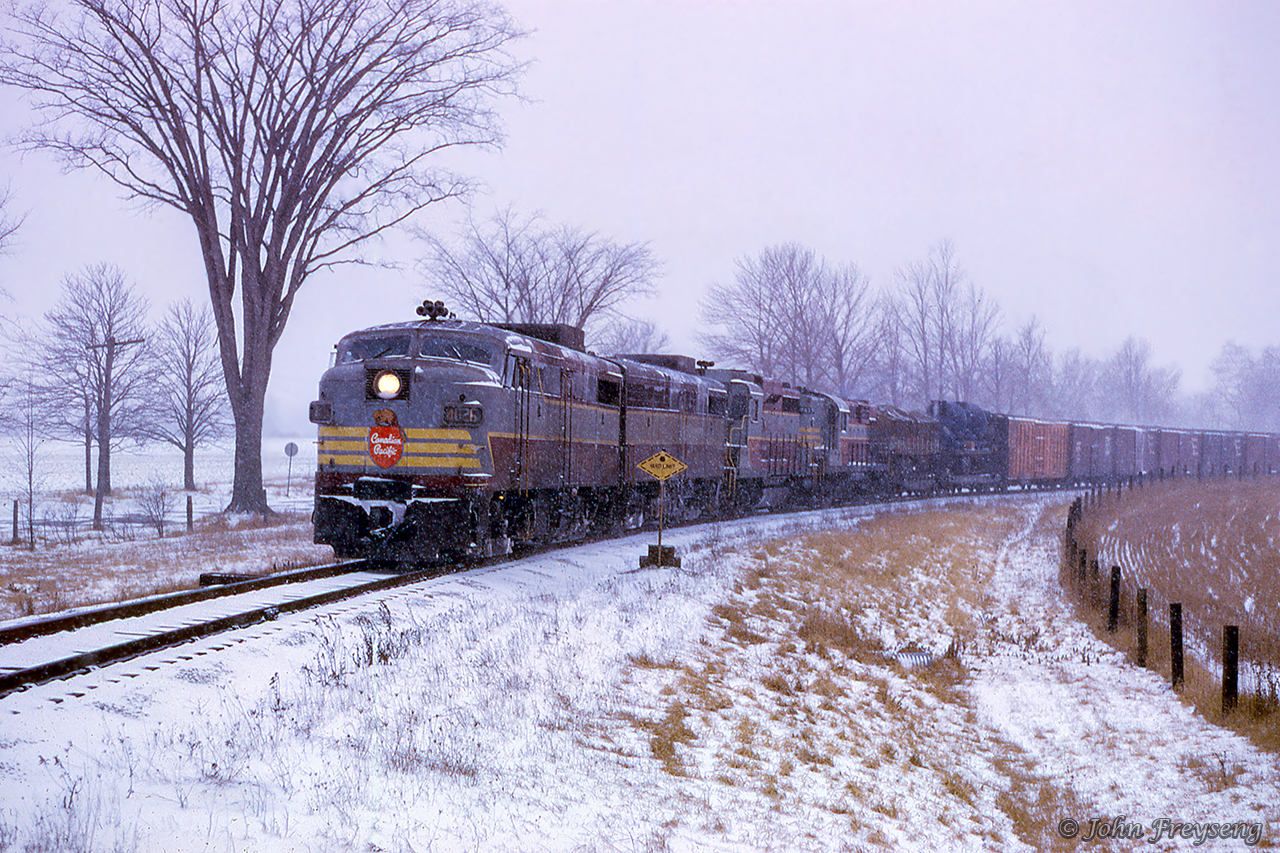 CP 902 departs Agincourt Yard for Montreal via the Staines Lead, approaching the junction with the Oshawa Subdivision.  Note GMD GP30 8200 third up.  Delivered in March 1963, it and sister 8201 were renumbered to CPR 5000 and 5001 in 1965.  Both survive today, with the 5000 at the Alberta Railway Museum, and the as a grain elevator switcher in Fremont, Nebraska.Scan and editing by Jacob Patterson.