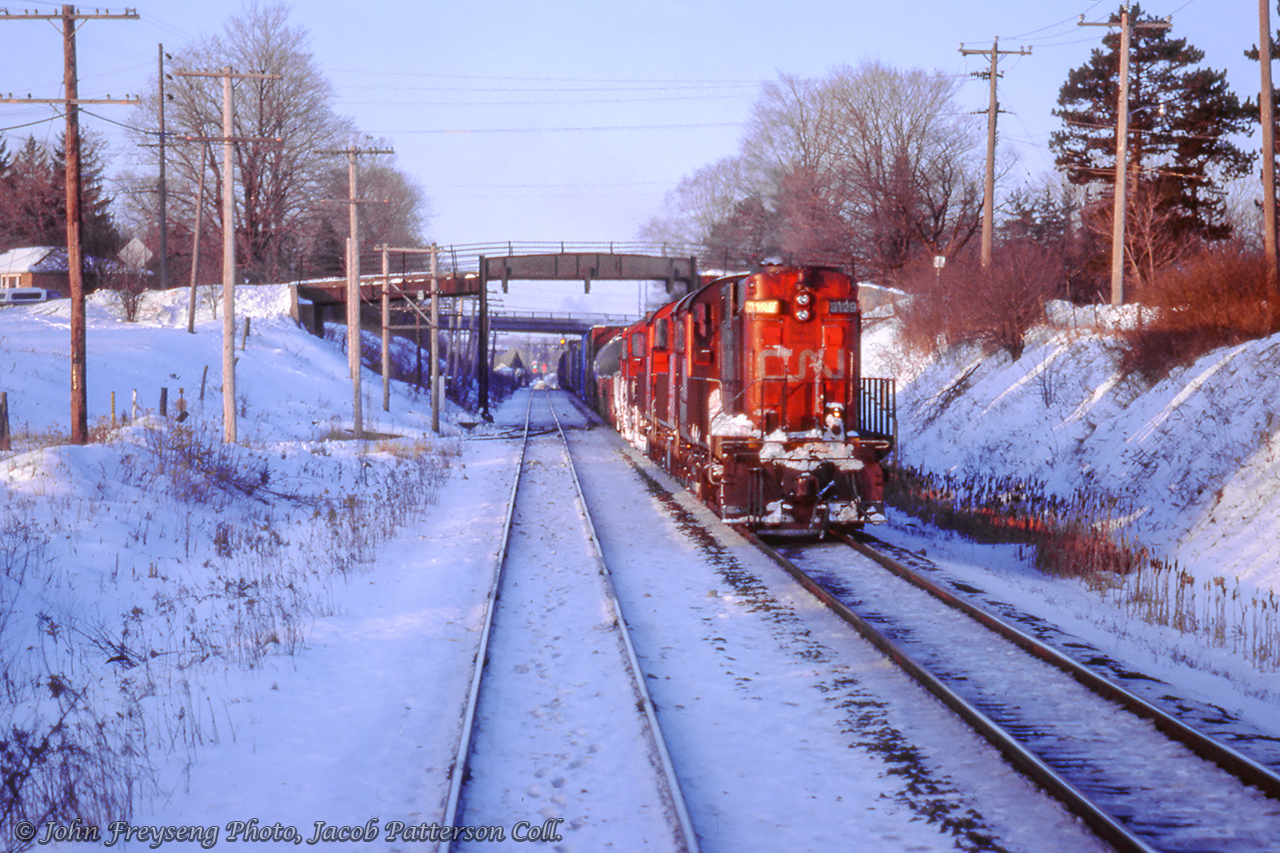 An eastbound freight for Mac Yard, led by RS18 3129, is seen waiting on the north track at Credit for 
our train, RDC-equipped VIA 661, to clear before proceeding eastward.  Just prior to crossing the Credit River, both trains had been held for late running VIA 660 from Stratford.John Freyseng Photo, Jacob Patterson Collection Slide.