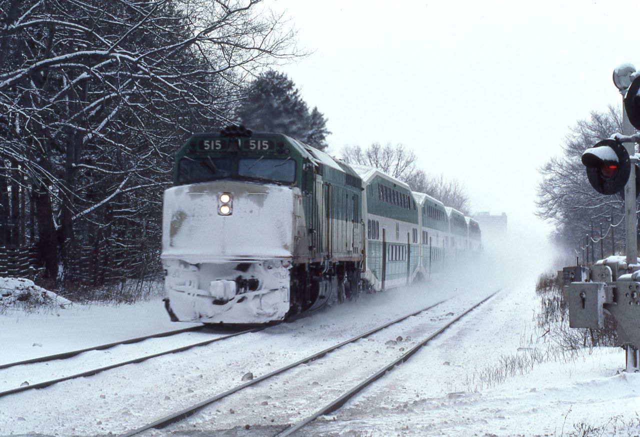 GO Transit F40PH #515 kicks up snow as it races away from its stop at Clarkson, Ontario on January 19, 1985.  The unit was built in May 1978 and eventually sold to Amtrak as their 415.