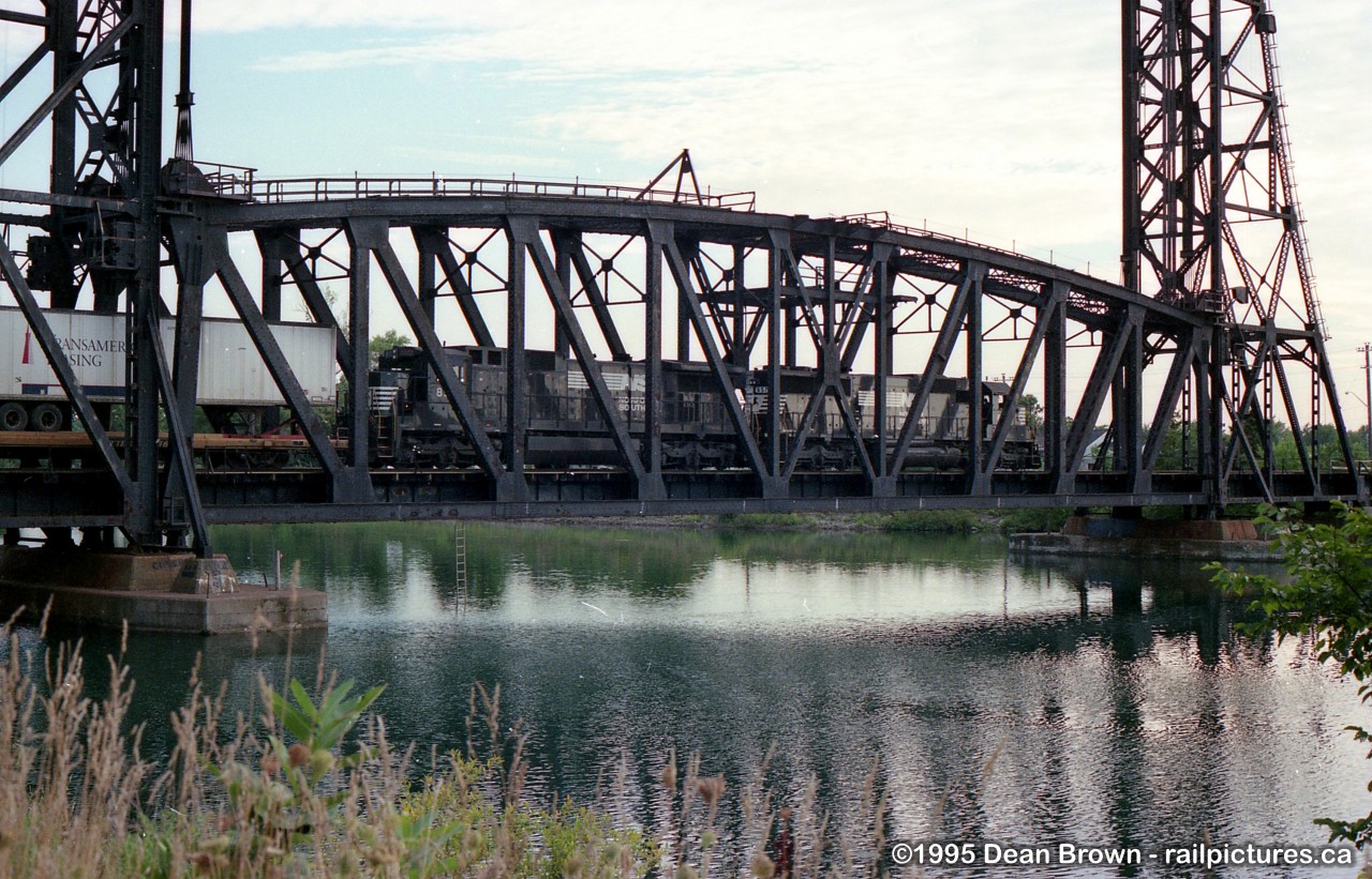 NS 445 departing Dain and crossing over Bridge 17 over the old Welland Canal heading to Feeder South for Fort Erie and onto Buffalo back in 1995.