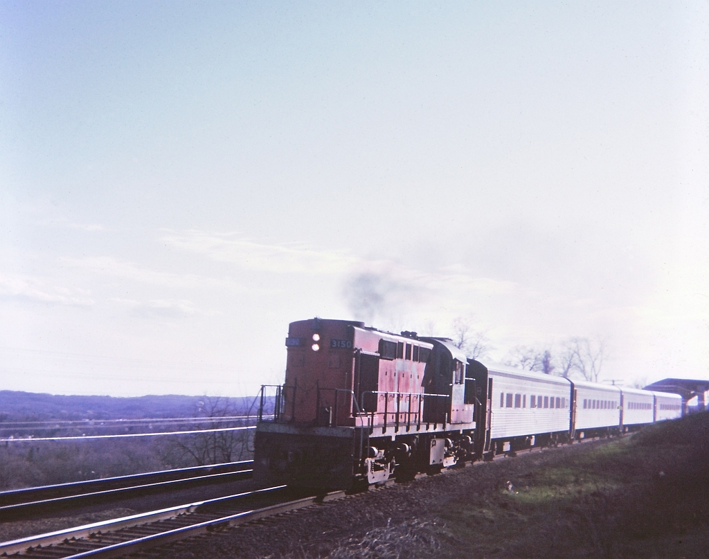 CN 3150 in TEMPO paint scheme and 4 TEMPO coaches drifting along at speed late afternoon. For those familiar with the area, in the background at the rear of the train can be seen the new double lane bridge under construction on Sydenham Rd which replaced the old hump back single lane bridge. Not a bad image for a 53 year old "Kodak Instamatic Moment".