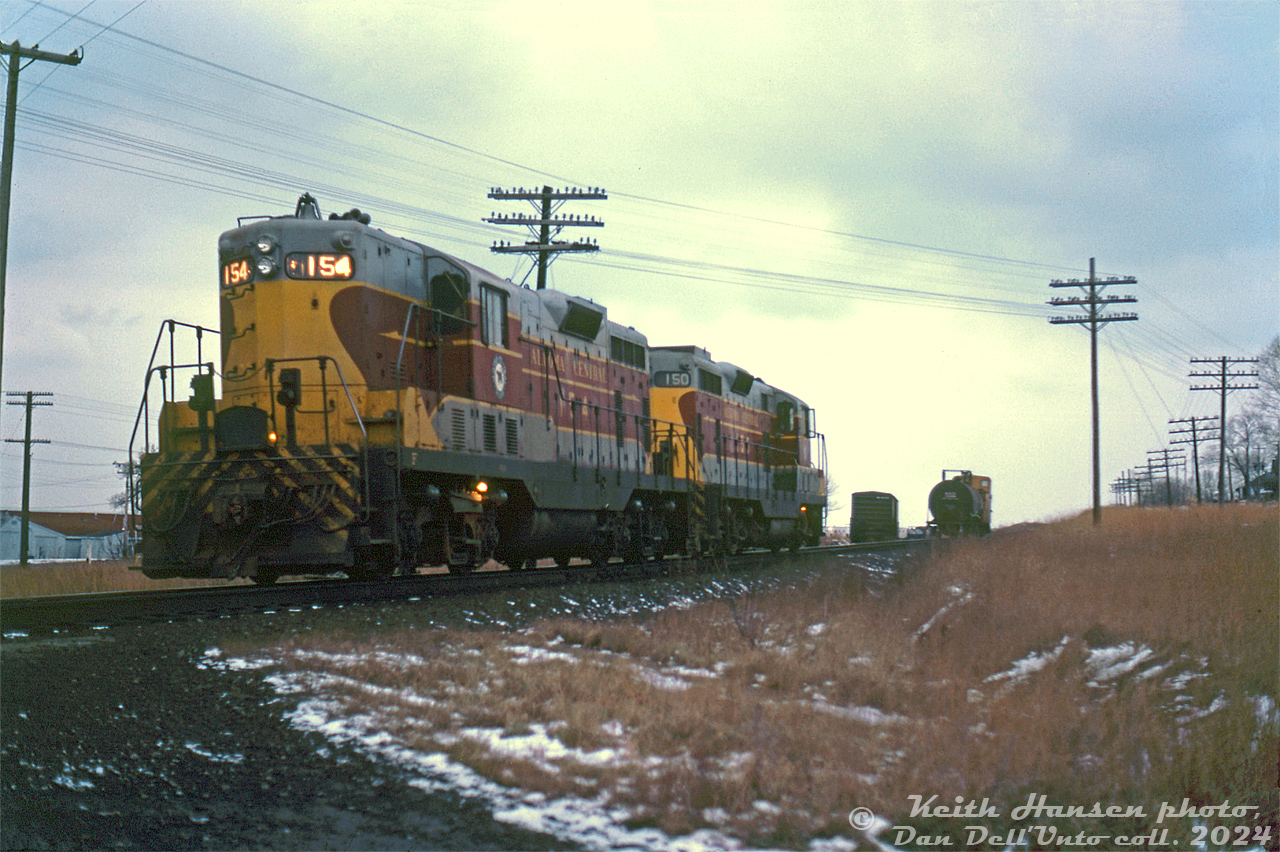 Algoma Central Railway GP7's 154 and 150, leased by CP Rail for a time in 1978-1979, work the interchange track in Port Hope after making their way east with CP's Cobourg Turn on the Belleville Sub from Toronto Yard. The two units are seen at the interchange switch around the old Smith Street grade crossing (now closed). The interchange track led downgrade to a small CN yard off the CN's Kingston Sub, near the present day VIA Rail station.

Keith Hansen photo, Dan Dell'Unto collection slide.
