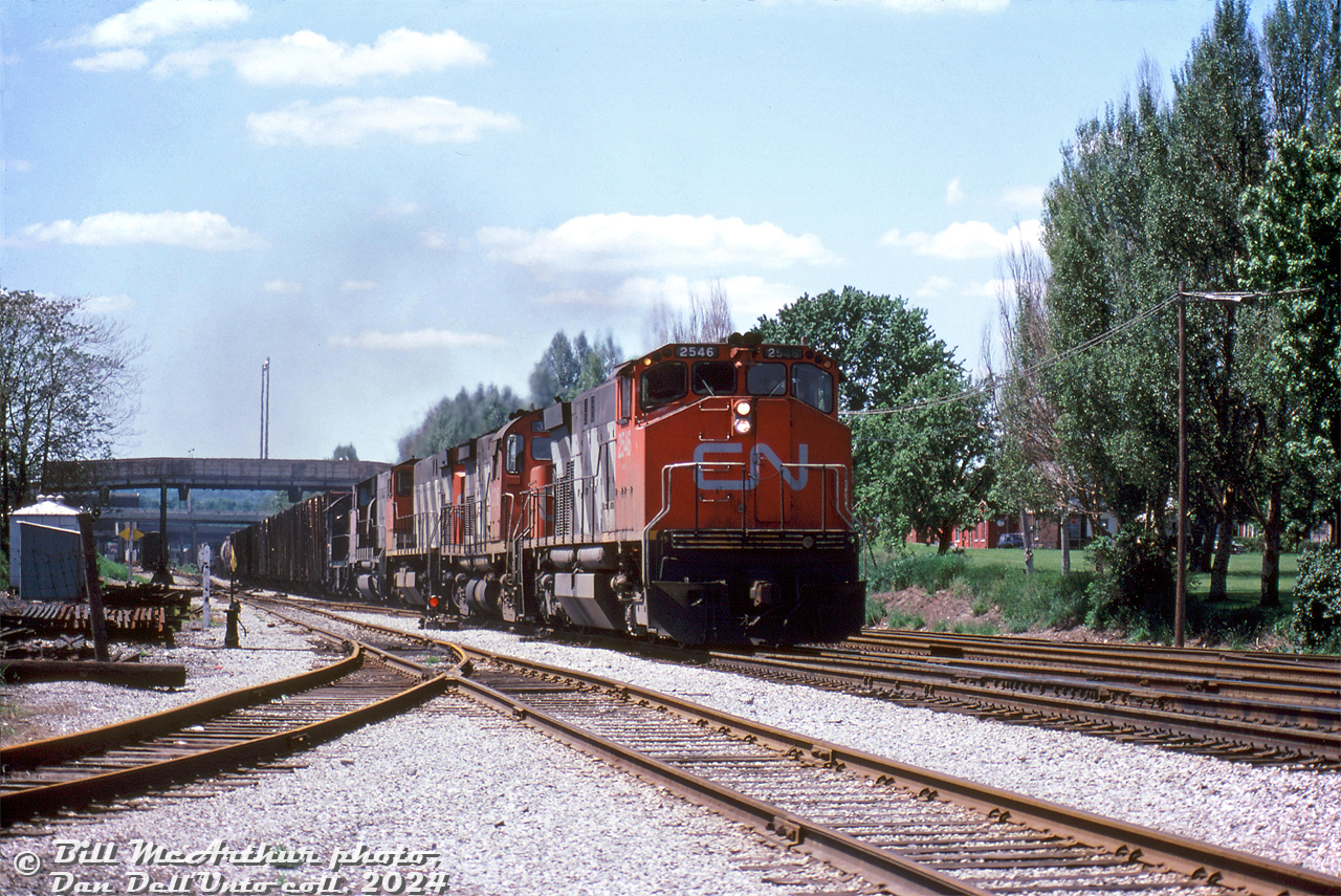 CN M420 2546, C424 3218 (with a really saggy frame), M420 2504, GP40-2L(W) 9522, and S7 8226 head up freight #431, having just finished working Stuart Street Yard and now on the move eastbound through Hamilton on the Oakville Sub (timetable west) just transitioning to the Grimsby Sub (timetable east) at the old James Street Station site in the distance. The train is seen passing under Mary Street, John Street and James Street bridges, and passing by the old junction point around Mile 43.6 where the Hagersville Sub branched off to the south at Ferguson Avenue (gone today), and the N&NW spur to the north into the industrial district.

Bill McArthur photo, Dan Dell'Unto collection slide.