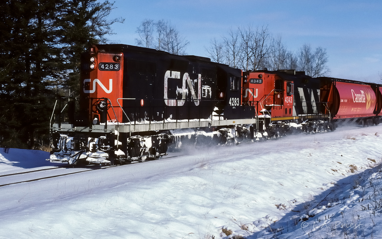 The noodle scheme on a GP9 in the mid-eighties was a tough catch on the Coronado. Plenty of GP38's went by with this paint job, I only saw and photographed 2 GP9's. In May of 1985 the 4368 passed through town and then this photo of the 4283 from 1986. On this day, the 4283 and 4343 were making good speed hauling 25+ grain loads as the train came around the corner at mile 24 that leads to Coronado. It looks like a few wind drifts of snow were driven through on the way home. Cab 79836 on the end, photo time was 11:30.