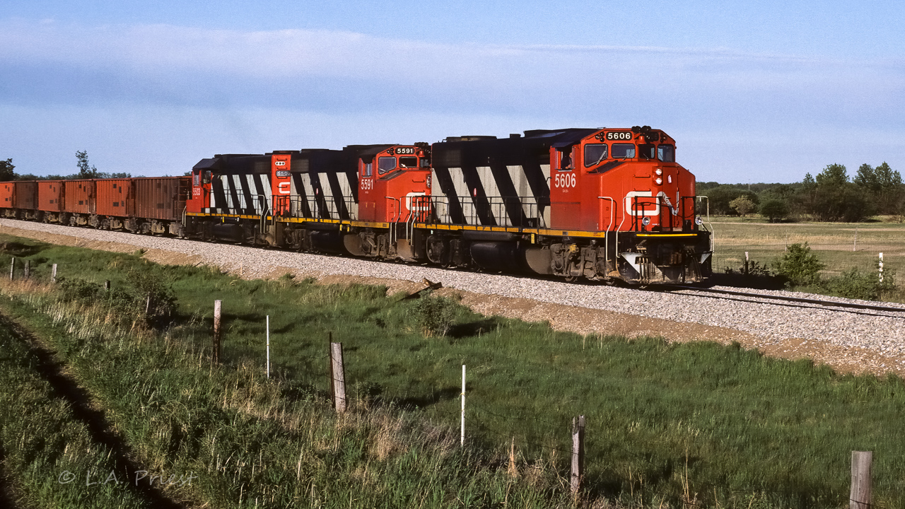 Although there is fresh ballast on the track and ballast hoppers in the train, the two are not connected. The crew of the 5606 will have stopped wherever the work was being done on the Lac La Biche Sub. and picked up the 15+ empty ballast cars to bring back to Edmonton. The ballast on the track was applied by the work train that had been working in our area for the previous couple of weeks. The whole route to Fort Mac was getting a major upgrade. Behind the empty ballast cars there were 35 loads of sulphur and cab 79511. Photo taken at mile 26.6.