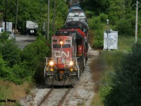 With more units than cars, CN L540 is viewed approaching Stirling Avenue in Kitchener, Ontario on the Huron Park Spur as it heads to the interchange with CPKC on the Huron Park Spur where the crew will lift and set-off. L540 was powered by GP38-2’s 4726, 4732, 4725 and had GP38-2’s 4902 and 7524 on the rear. The latter two units were just along for the ride as they weren’t running and were being sent back to MacMillan Yard in Toronto. July 13, 2023.