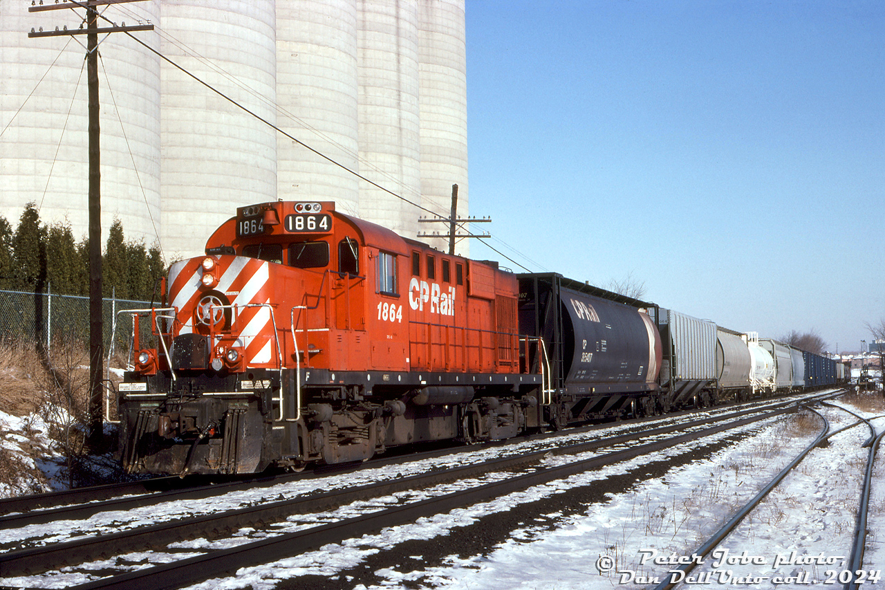 CP RS18u 1864 handles the "Stone Train" local, seen here posing by the Christie Brown mill at Mississauga Road in Streetsville during the late afternoon (possibly doing some switching work).

The Christie Brown (Nabisco) mill here was originally opened under Reid Milling in the 1830's, and is presently operated by Ardent Mills. Off the service track on the right, a switch can be seen for the spur to another mill in Streetsville, the ADM mill (originally Barber Brothers, later McCarthy Milling).

Peter Jobe photo, Dan Dell'Unto collection slide.