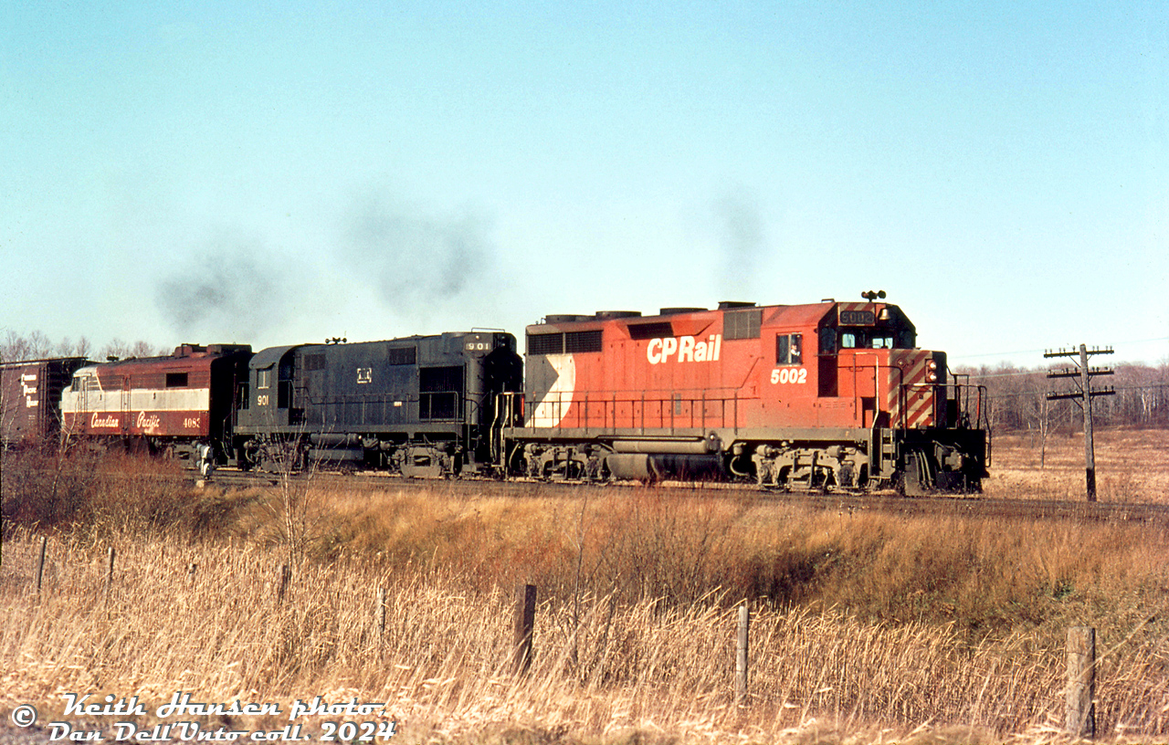 CP GP35 5002, ALCO RS27 901 and CP FPA2 4083 handle a freight on the Belleville Sub at Darlington ON, passing a barren late fall landscape sometime in November or December 1971. The exact location is not noted, but it appears to be eastbound at Baseline Road at the east end of Darlington siding.

ALCO 901 was originally one of four RS27 units built for the C&NW, who traded them back to ALCO after a few years for new C425's. ALCO then painted them black, and leased two (900-901) to CP in the early 1970's. While on lease, they changed hands to Precision Engineering Co (PECO), and then Precision National Corp (PNC), still on lease to CP. 901 later ended up on the Minnesota Commercial as their 318 (now stored), and sister 900 on Peabody Coal (since scrapped).

CP 5002 was CP's first GP35 (numbered above the two GP30 units, and originally delivered as CP 8202). It would eventually become CP control cab/slug 1125. The 4083 trailing, one of CP's freight-passenger FPA2 units, would catch fire the next year and be retired.

Keith Hansen photo, Dan Dell'Unto collection slide.