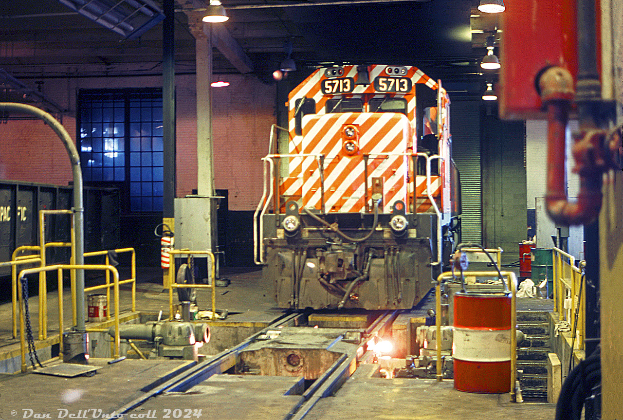 CP Rail 5713, one of CP's growing fleet of SD40-2 units, sits inside the shops at Alyth Yard in Calgary awaiting attention from shop forces. It appears to be occupying the wheel lath section of one stall, with a drop pit area and wheel lathe for profiling locomotive wheels.Original photographer unknown, Dan Dell'Unto collection slide.