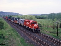A CP eastbound intermodal train is heading through Milton, Ontario on the Galt Subdivision viewed from the hillside of the CN Halton Subdivision. The consist included freshly repainted CP SD40-2 5743 and Precision National (PNCX) SD40 3107, which was ex-UP 3107. At the time, CP had a group of 7 PNCX SD40’s leased as part of their rapidly expanding mid-90’s lease fleet. 