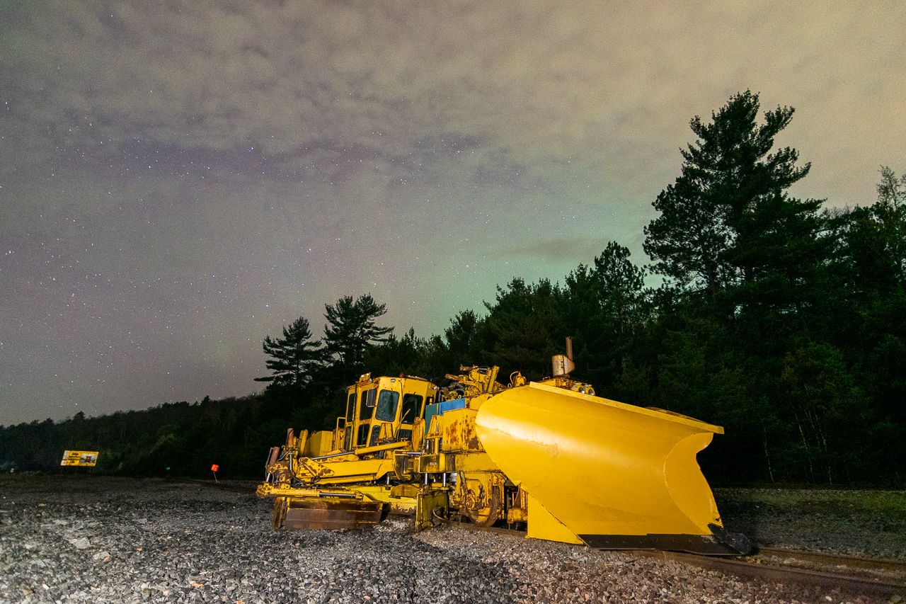 I debated on whether or not to post this one, or whether I should wait to repeat this photo under a more impressive northern lights display, but here you go anyhow! A piece of snowfighting equipment (owned by Mansour, I think? Anyone know reporting marks for this unit?) begins its long summer rest as the fading pillars of a solar storm disappear northward. There was a strong display about a half hour earlier, which I shot above Onaping High Falls.