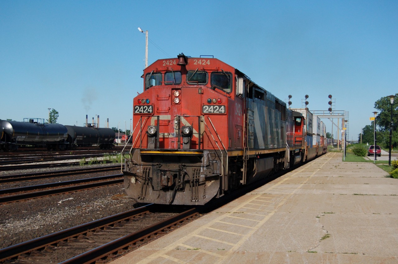 CN Dash8-40CM 2424 and GP40-2L 9424 have intermodal train 148 on the north track past the station at Sarnia, Ontario.