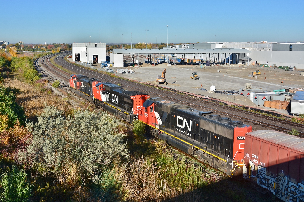 The final day(s) at the Hopkins St overpass....


   Construction of the GO East Rail Maintenance Facility progresses, 


  CN 271, with CN  8889 / 2191 / 5442  combo:  SD70M-2 /  Dash 8-40 CW  / SD60  on the south service track lifting Oshawa autoracks,


  From the since removed Hopkins St overpass, Whitby, October 12, 2016 digital by S.Danko


   Noteworthy: 


Subsequently, the GM Oshawa plant(s) ceased production December 2019. And as of November 2021 GM Oshawa restarted 1500 and 2500 series pick up  truck production.


More


      CN 271   


sdfourty