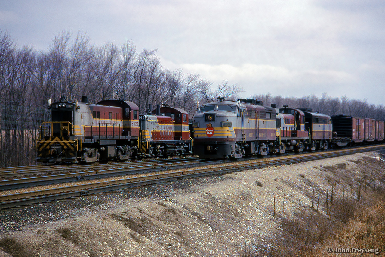 With almost entirely MLW power in the scene, a pair of westbound extras meet at First Line.  Extra CP 8027 works the yard at Guelph Junction while extra CP 4050 flies past on the main.Scan and editing by Jacob Patterson.