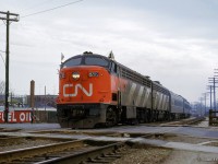 CN CLC C-liner 6705 and a GMD B-unit lead the second section of train 54, the <i>Bonaventure,</i> across Pape Avenue in Danforth.  At left is coal and fuel oil yard number 6 of the <a href=https://www.trha.ca/trha/wp-content/uploads/2013/03/252317.jpg>Milnes Coal Co.</a> at 354-358 Pape Ave.


<br><br><i>Scan and editing by Jacob Patterson.</i>
