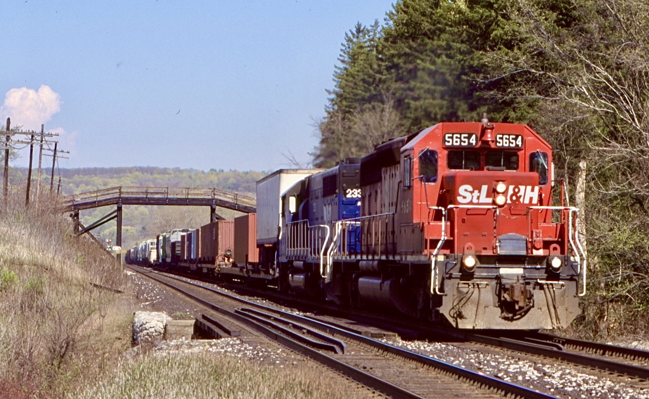 After loosing the MLW’s just months earlier it seemed that things on CP were a little less exciting, little did I know at the time I would actually miss the countless SD40’s years later.  At the time I believe trains 512/513 ( I may have the numbers wrong) were the most interesting, often with a mix of CP and I&M Railink power. Of course I preferred the IMRL SD45’s over the SD40’s, but you take what you get. Here westbound 513 climbs the Niagara Escarpment just east of Campbellville with a StL&H leader and IMRL 233 ducking under the well know wooden farm bridge.