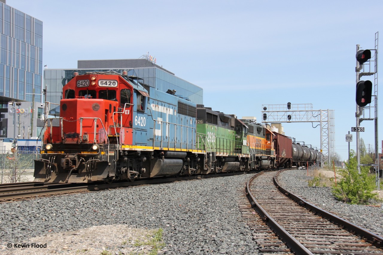 CN L568 begins its journey west towards Stratford with a small train and an eclectic lash-up, almost representing Google colours, as it so happens to be passing by the Google building. Power was GTW 6420-BNSF 2926-BNSF 2090. The latter two units were assigned to the Kitchener pool for over three months at the time of this image. This power set is now split up as many of the local guys are aware. Immediately after this power was sent back to Toronto and replaced with new power, a trove of railfans flocked to the Guelph Sub west of Kitchener for a trio of GP9s leading 568 on May 24. If I'm not mistaken, BNSF 2090 is on CN 580 out of Brantford, and BNSF 2926 went away on CN 421 to an unknown destination on May 30. I'm not sure where the GTW 6420 is now. BNSF 2098 may be next to roam the Guelph Sub - time will tell.