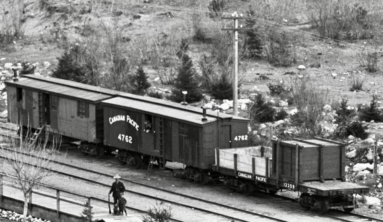 As one example of the astonishing level of detail in the Archibald Murchie glass negative of Keefers recently posted (http://www.railpictures.ca/?attachment_id=54515), consider this extreme crop zoomed in to the group of cars near the depot.

No specific date provided, but Mr. Murchie became photographically active in 1893, so the general era of 1890s reported for that photo is believed accurate.  I wonder, is that Mr. George Alexander Keefer, surveyor and construction engineer during the Onderdonk era, and namesake of that CP station, standing on the platform with a rifle and a child and a dog?