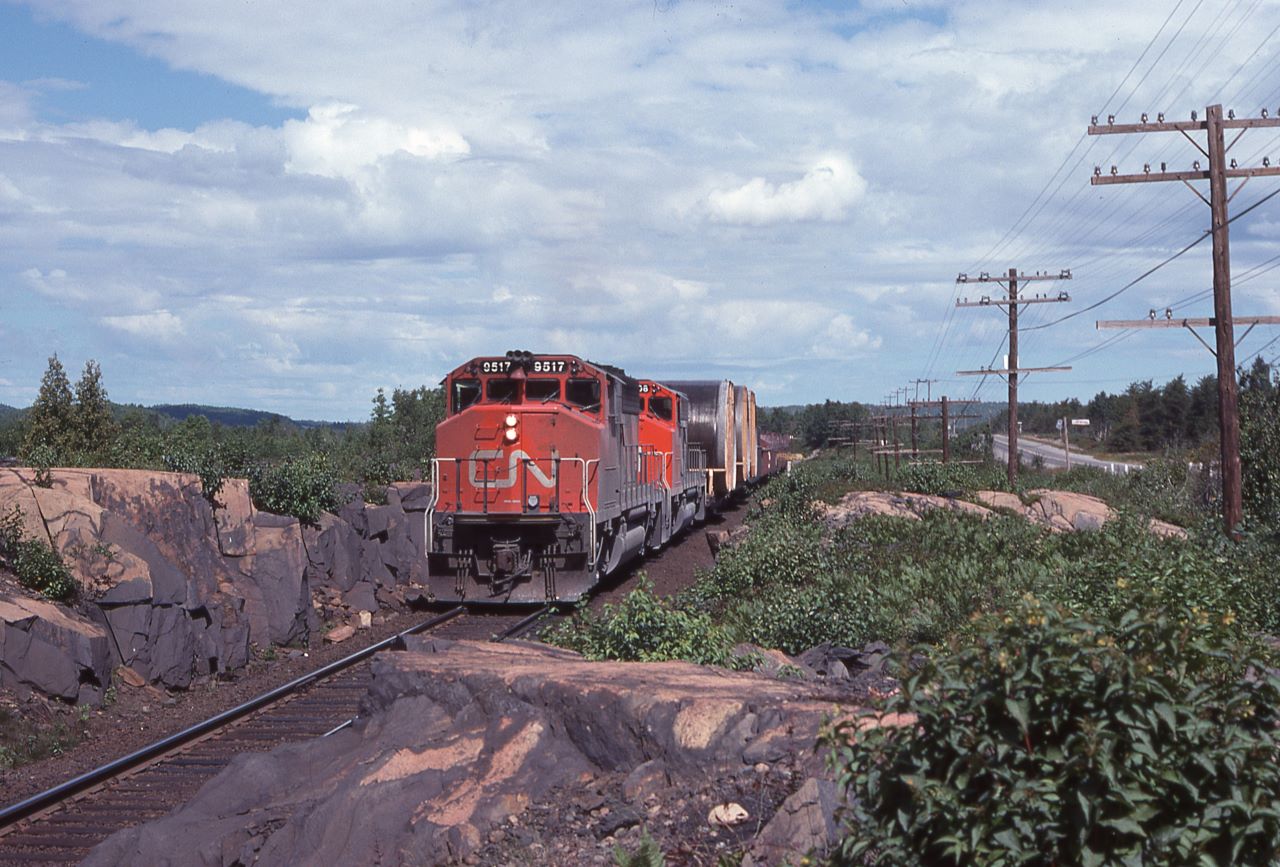 A southbound train pulls out of Capreol, Ontario with three unusual high and wide loads next to the engines.  Power consisted of 9517 and 9608.