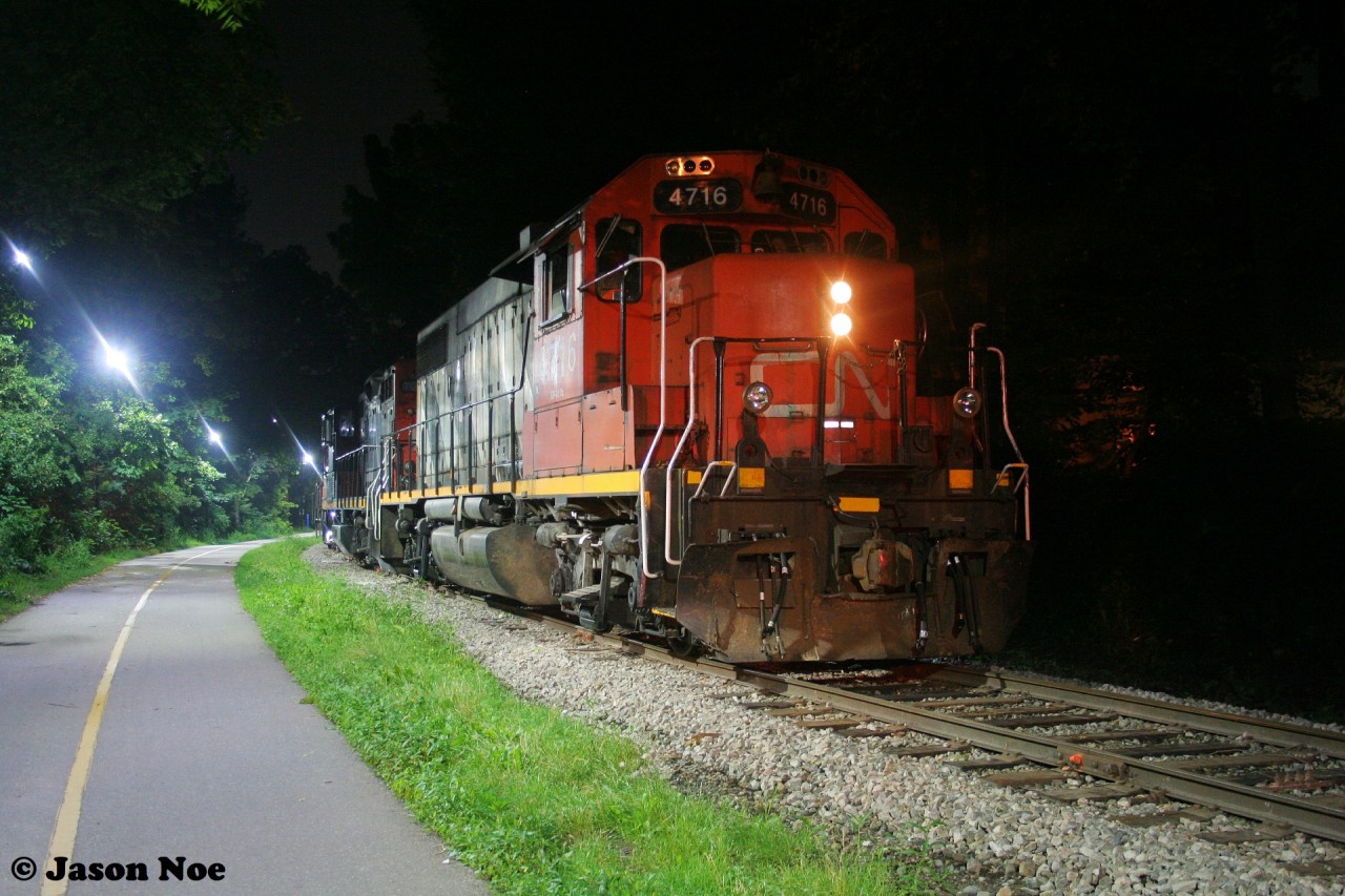 CN L566 with GP38-2 4716 and GP9RM 7038 are viewed waiting near William Street in Waterloo, Ontario for their yellow signal to proceed north on the ION portion of the Waterloo Spur to Elmira.