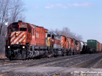 Late 80's leased and MLW power: a westbound extra freight works the west end of Guelph Junction with plenty of power up front: CP M630 4573, leased Algoma Central Railway SD40-2 183 (a flag bracket off the rear of 4573 making it look like 133), RS18's 8765 and 8781, and SW1200RS 8161 (one of the old GRR-assigned regulars). Other photos show 8781 may have been lifted or set off a Guelph Junction, and 8161 was likely heading west to be set off at Galt.<br><br><i>Bill McArthur photo, Dan Dell'Unto collection slide.</i>