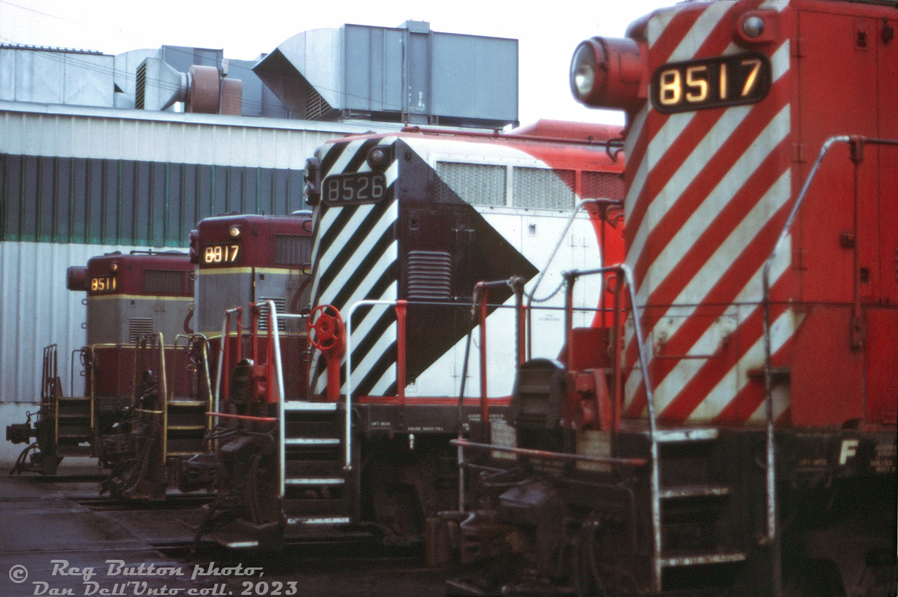 CP Rail GP9's 8517, 8526, 8817 and 8511 sit parked outside the Alyth Yard diesel shop in Calgary awaiting attention from shop forces. Two sport the newer "Action Red" livery with end stripes and large multimark, while the other two retain their 1960's maroon & grey "Script" livery.

Most of CP's GP9 fleet was based out west, specifically assigned out of Alyth, Winnipeg, and later Nelson. The three 8500's here were Alyth-assigned dual freight/passenger units, part of a group equipped with steam generators (8501-8529) for use as passenger protection power on The Canadian and other passenger trains CP operated. Dynamic brakes enabled them to be used west of Calgary on the mountain grades, and the split 800/800gal fuel & water tanks underneath necessitated the air tanks (or "torpedo tubes") to be mounted on the long hood behind the cab. Among the differences, 8517 and 8511 sport the Pyle single beam "barrel style" headlight earlier units were delivered with, while 8526 and 8817 feature the later Pyle dual sealed-beam headlights.

Many of these units lasted into the 80's as passenger protection power for VIA's Canadian, but were slowly cycled into the rebuild program, emerging as chop-nose GP9u units without steam generators for yard and roadswitcher work.

Reg Button photo, Dan Dell'Unto collection slide.