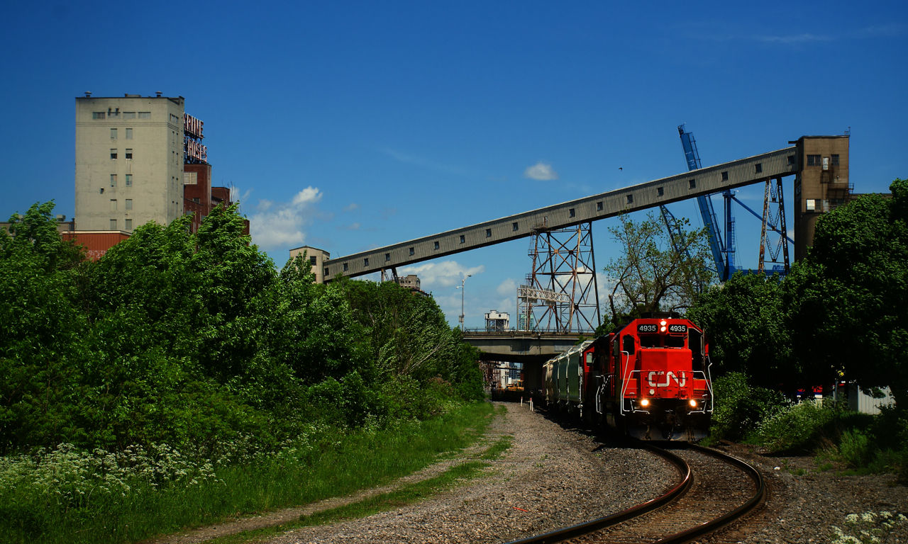 CN 500 is leaving the Port of Montreal with hoppers and baretables.