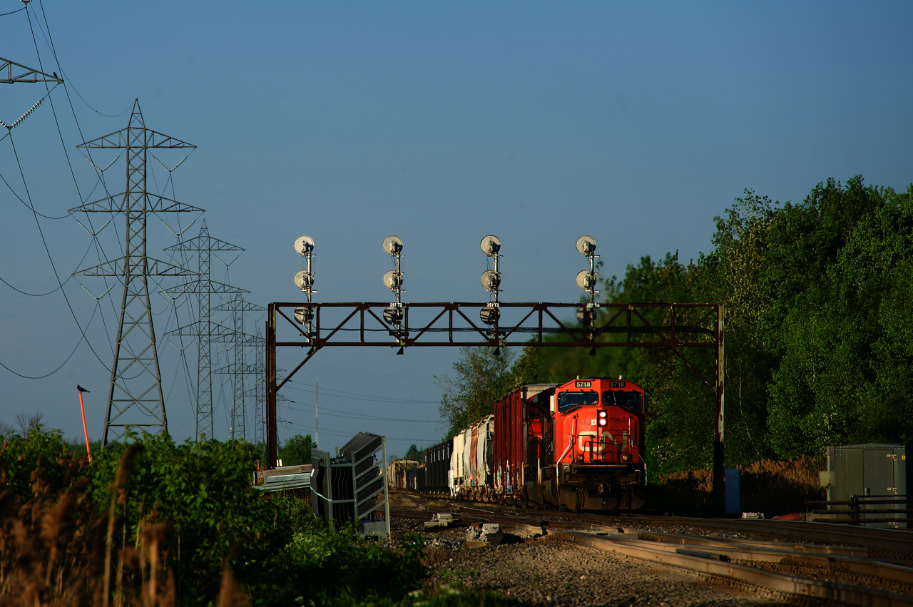 CN 321 is passing under a vintage signal bridge as it prepares to do a tail end lift at Coteau. Work has already begun on replacing the various signals around Coteau, including this one.