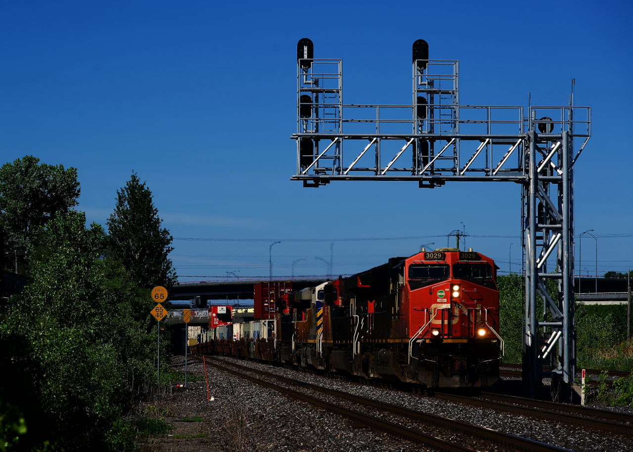 CN 120 is passing underneath a signal gantry with four GEs up front.