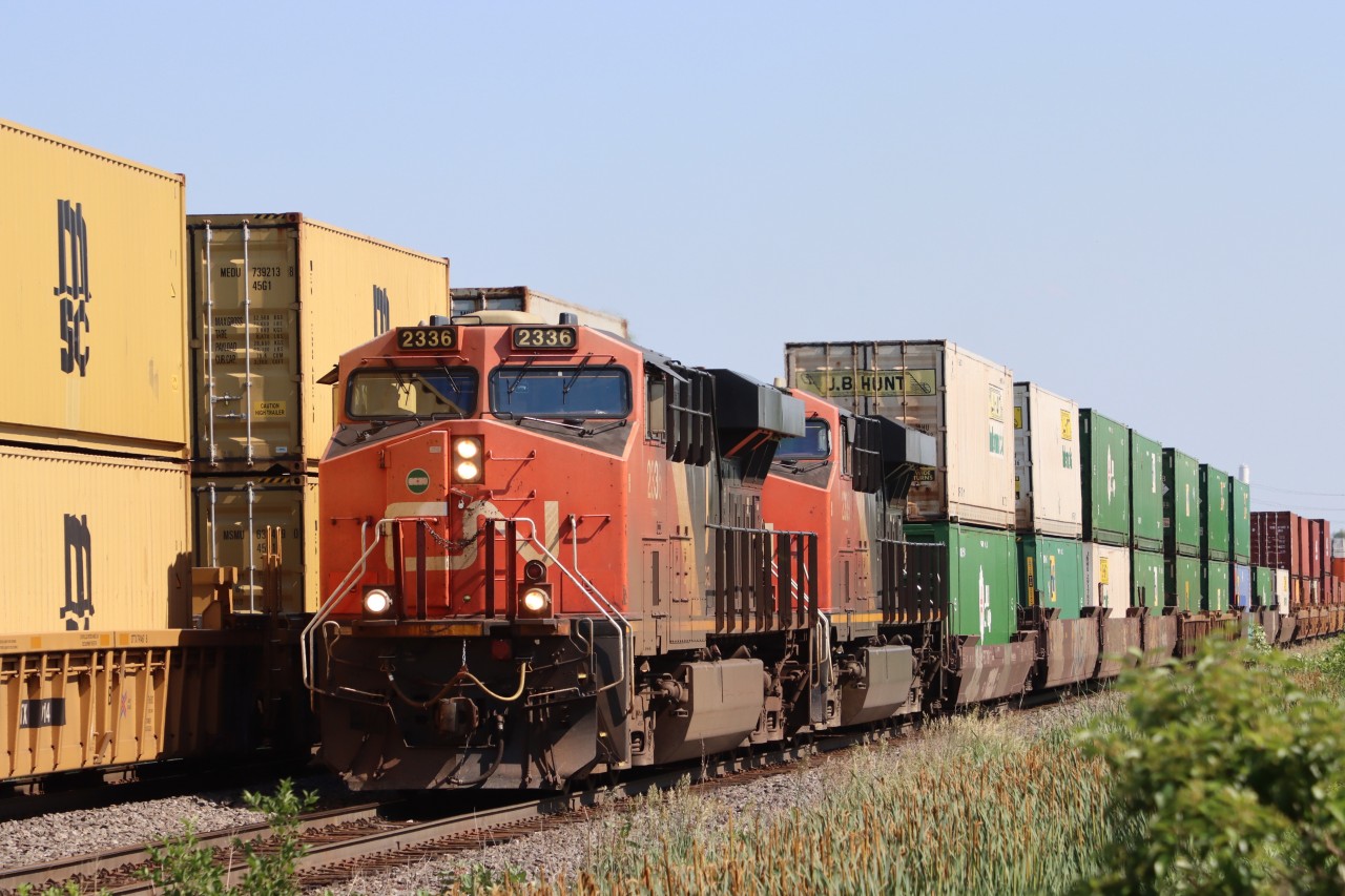 Operating on a Clear to Stop signal and having received permission from the Rule 42 Foreman to proceed by the Red Flag at Mile 44 Halton Sub., CN 2336 slowly works its way eastbound up the north track toward Tansley as a westbound passes on the south track.