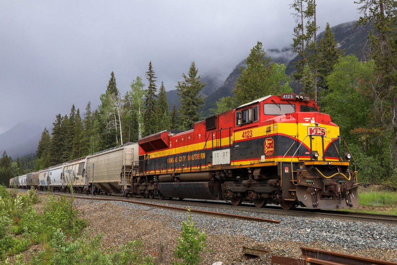 KCS 4123 brings up the rear of CPKC 301, as they work downgrade west of Palliser on a stormy day on the Mountain Sub.