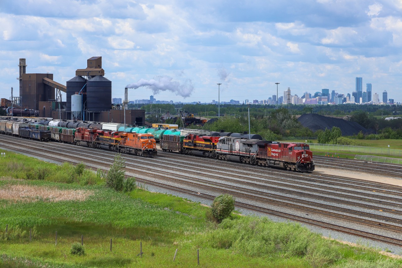 CPKC 418 arrives Edmonton with CP 8781, wearing the Hapag-Lloyd St. John Express scheme.  In the yard is KCSM 4859, which features a special safety scheme.