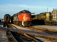 A sunny summer evening finds an assortment of power from three builders at the west end of London's passenger station.  At right is train 51, the <i>Huron,</i> from Toronto - Port Huron, Michigan via Kitchener, with a pair of EMD GP9s (4918/4950), while at left is train 41, the <i>Erie</i>, from Toronto - Windsor via Brantford, with a CLC CPA-16-5 (one of only six built), and an MLW RS18.  These CLC units were built with a five axle wheel arrangement, as seen better in<a href=https://www.railpictures.ca/?attachment_id=35044>Dave Burrough's photo.</a>



<br><br>The time would be approximately 1918h if everything is on schedule, with 51 arriving at 1905h, and 41 arriving at 1915h, both trains will share the station for five minutes, when 51 will depart at 1920h, with 41 following towards Komoka at 1925h.



<br><br>203 Bathurst Street can be seen off to the right.  Originally built as the Holeproof Hosiery Company in 1919, the company merged with the Julius Kayser Company in 1955, and was later sold to the Chester H. Roth Company in 1958, being renamed Kayser-Roth.  The company closed the factory in 1989, but the building still exists today as City Centre Storage.

<br><br><i>Scan and editing by Jacob Patterson.</i>