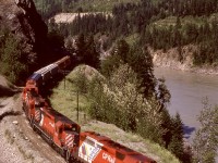 In the canyon of the Fraser River between Keefers and Chaumox, just a bit north of a bridge over the Nahatlatch River, a high and long gravel bank above a curve at mileage 113.5 provided a glorious elevated view of CP’s Thompson sub., and on Wednesday 1987-06-24 that perch was used to record a westward grain train with lead unit CP 5748 carrying Expo 86 markings and assisted by 5594 + 5772 + 5676.