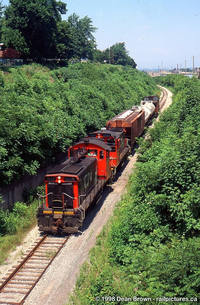 CN 549 with CN SW1200RS 1385 and 1388 climbed the grade at Service Rd. W. on the CN Thorold Sub from Merritton to Thorold in July 1998.