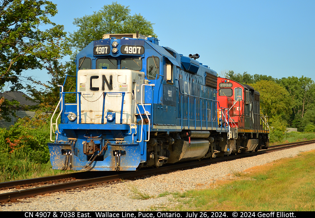 To the rescue...  CN 'blueberry' #4907 and CN 7038 are running light eastbound down the VIA Chatham Sub to grab the rear 5 cars of CN train #438.  Unsure what exactly happened, but from what I've heard, 438 pulled a drawbar and had to pull the bad order car east all the way to Stoney Point so set it off in the siding.  The 5 cars were blocking Old Tecumseh Road for quite some time with the O.P.P. reporting a derailment, but that was not the case.  I'm sure we'll hear more about this over the next few days.  I just happened to be in the right place at the right time for a change.